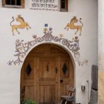Mit Fassadenmalerei («Sgraffito») verzierter Hauseingang in Guarda_Entdeckungstour durch das malerische Engadin